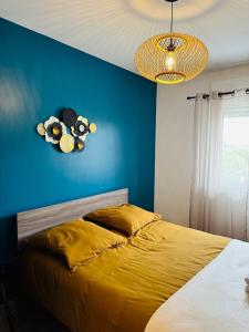 una camera da letto con un letto con una parete blu di Cosy and Chic Appartement moderne proche gare a Mantes-la-Jolie