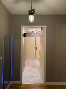 un corridoio con porta bianca e pavimento in marmo di Cosy and Chic Appartement moderne proche gare a Mantes-la-Jolie