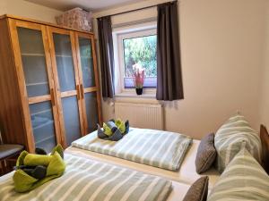 two beds in a room with a window at Ferienwohnung Schatzkiste in Lintelermarsch