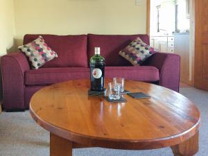 a bottle of wine on a coffee table in a living room at The Pump House in Hawkesbury