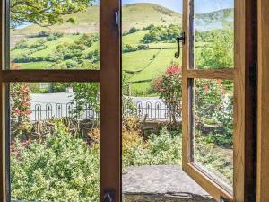 una ventana abierta con vistas a una casa en Yr Efail - Hw7387, en Llanymawddwy 4 fotos más