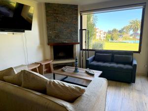 MAITENCILLO VISTA BOSQUE y MAR في مايتنسيلو: غرفة معيشة مع أريكة ومدفأة