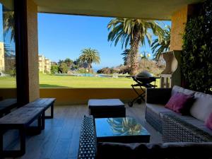 MAITENCILLO VISTA BOSQUE y MAR في مايتنسيلو: فناء مع أريكة وطاولة والنخيل