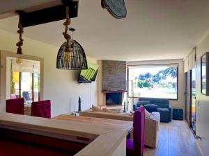 MAITENCILLO VISTA BOSQUE y MAR في مايتنسيلو: غرفة معيشة مع طاولة وكراسي وغرفة معيشة