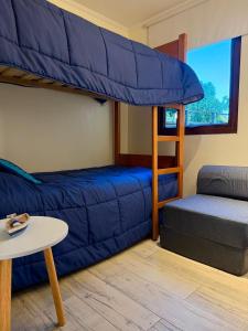 MAITENCILLO VISTA BOSQUE y MAR في مايتنسيلو: غرفة معيشة مع سرير بطابقين وأريكة +17 صورة