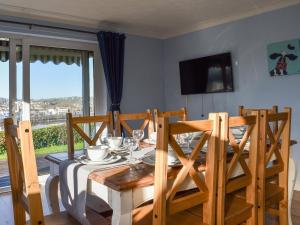 a dining room with a table and a television at The Orchard in Bideford