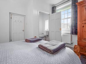 una camera da letto con un letto con due asciugamani sopra di The Cottage a Stocksfield Altre 5 foto
