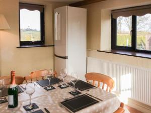 a kitchen with a table with wine glasses and a refrigerator at The Pump House in Hawkesbury