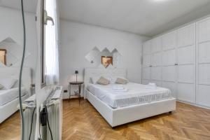 a white bedroom with a large white bed and a table at Honey Terminal in Bologna