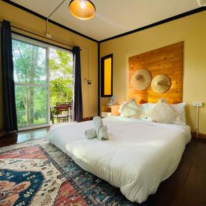 a large white bed in a room with a large window at Mangrove bungalow & restaurant in Ko Kood