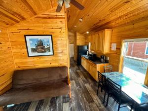 a dining room and kitchen in a log cabin at Bonanza Camping Resort in Wisconsin Dells