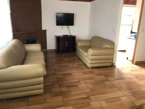 un soggiorno con due divani e una TV a schermo piatto di Chácara / Casa de Campo a Bragança Paulista