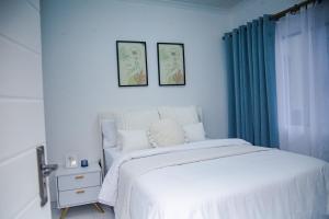 a bedroom with a white bed and blue curtains at Pure Bliss Ocean Apartment in Kingsborough +12 photos
