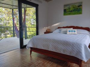 a bedroom with a bed and a sliding glass door at Eco-Cabañas Altozano Nimaima in Nimaima +142 photos
