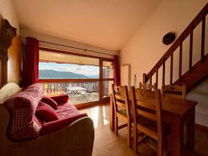 un soggiorno con un divano e una porta scorrevole in vetro di Appartement cosy T2 Duplex a Bolquere Pyrenees 2000