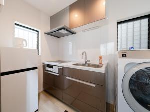 eine Küche mit Spüle und Waschmaschine in der Unterkunft Shibuya Sta 10min walk Kingbed VR Switch Wi-Fi in Wada