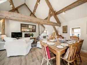 a living room with a wooden table and chairs at The West Barn in Hanley Castle