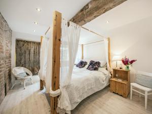 a bedroom with a canopy bed in a room at The West Barn in Hanley Castle +10 photos