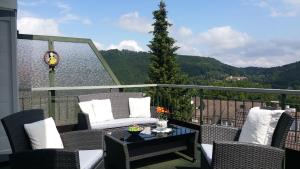 a balcony with chairs and a table with a view at 4 Sterne Ferienwohnung Anita in Badenweiler