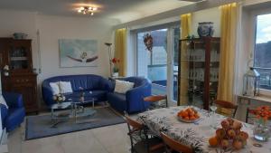 a living room with a blue couch and a table at 4 Sterne Ferienwohnung Anita in Badenweiler