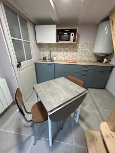 a small kitchen with a table and some chairs at Un petit cocon in Commercy