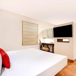 a bedroom with a bed and a desk with a television at Hotel Euro Star Alikara suite in New Delhi +18 photos