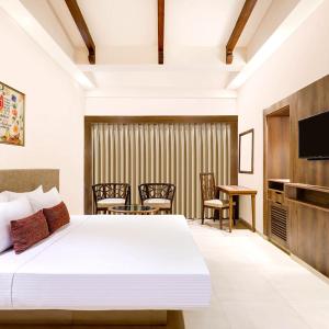a bedroom with a bed and a table and chairs at Hotel Euro Star Alikara suite in New Delhi