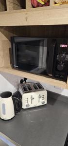 un microondas sentado en un mostrador junto a una taza de café en Serenity Nook, en Skegness 20 fotos más
