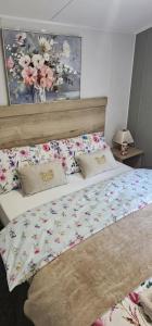 a bedroom with a bed with a floral comforter at Sunny Haven in Skegness +32 photos