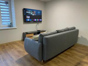 a living room with a couch and a flat screen tv at Apartament blisko Rynku "Kamienica" in Dębica
