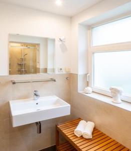 a bathroom with a sink and a mirror and a window at Charlot in Heringsdorf