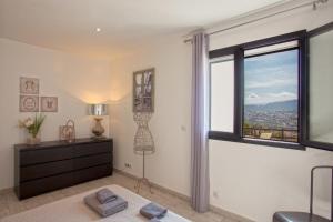 a bedroom with a window and a dresser and a bed at Casa Bianca in LʼÎle-Rousse