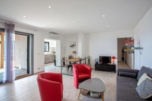a living room with a couch and red chairs at Casa Bianca in LʼÎle-Rousse