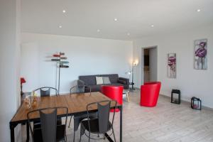 a living room with a wooden table and red chairs at Casa Bianca in LʼÎle-Rousse +18 photos