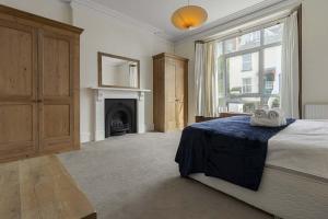 a large bedroom with a bed and a fireplace at Marina Cottage - Waterside Views Kingswear in Kingswear