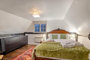 een slaapkamer met een groot bed met een groene sprei bij Boldshaves Cottage in Woodchurch