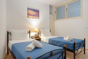 ein Schlafzimmer mit zwei Betten mit Handtüchern darauf in der Unterkunft Golden Horizon Villas Santorini in Akrotiri + 28 Fotos