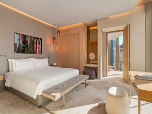 a bedroom with a large white bed and a desk at Rixos Premium Dubai JBR in Dubai