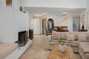 ein Wohnzimmer mit Couch und Kamin in der Unterkunft Golden Horizon Villas Santorini in Akrotiri
