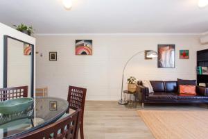 a living room with a couch and a glass table at Stay Okay Central - Fremantle in Fremantle