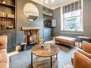 a living room with a table and a fireplace at Skye House in Bakewell