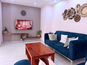 a living room with a blue couch and a table at Jay Jay Homes in Kampala