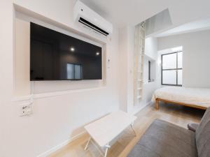 ein Wohnzimmer mit einem Flachbildfernseher an der Wand in der Unterkunft Shibuya Sta 10min walk Kingbed VR Switch Wi-Fi in Wada