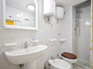 un bagno bianco con lavandino e WC di Versi di Sole a Bari