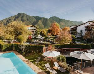 a resort with a pool and mountains in the background at Spa & Resort Bachmair Weissach, LUXURY FAMILY RESORT in Rottach-Egern