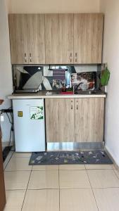 a kitchen with wooden cabinets and a white refrigerator at Markev Apartments in Vlorë