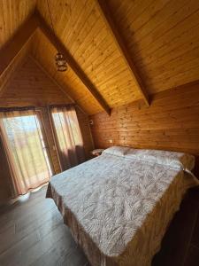 a bedroom with a large bed in a wooden room at Treeolives in Shkodër