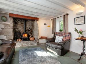 a living room with a couch and a fireplace at The Farm House in Porkellis
