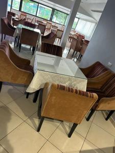 a dining room with a glass table and chairs at Treeolives in Shkodër +10 photos