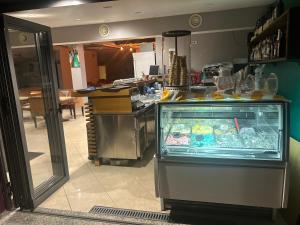 a food counter in a restaurant with a refrigerator at Treeolives in Shkodër